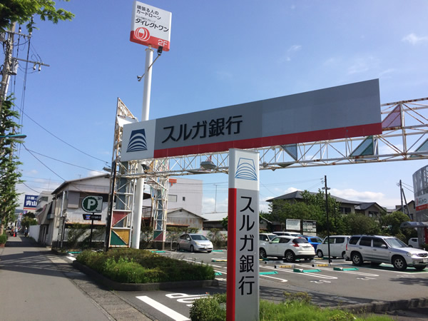 スルガ銀行の看板が右手に見えてきますので、敷地内にお進み頂き、ダイレクトワンの看板がある左側の入口より階段を上がって2階までお越しください。